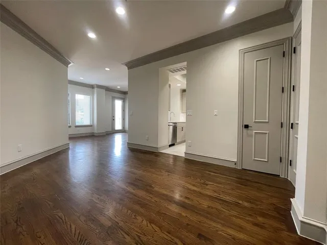 an empty room with wooden floor and closet area