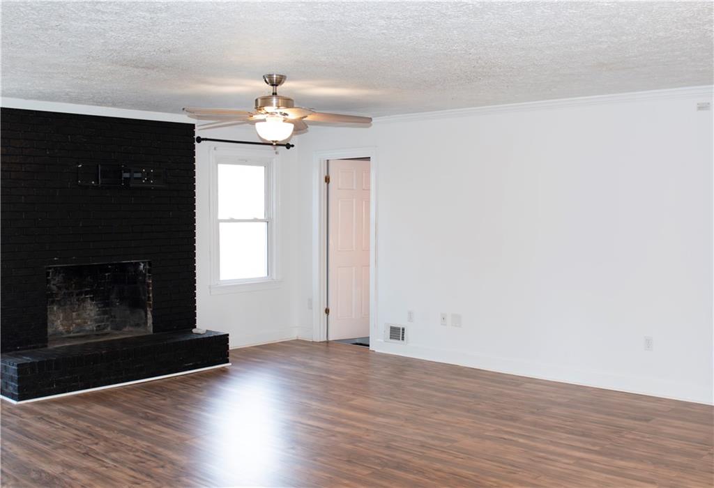 3626 Thompson Bend Gainesville, GA 30506 - Photo 3 of 14 a view of an empty room with wooden floor fireplace and a window