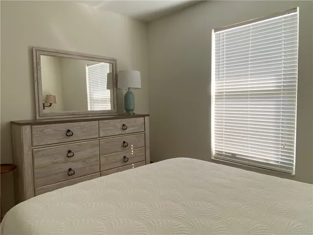 a bedroom with a bed and a mirror on dresser