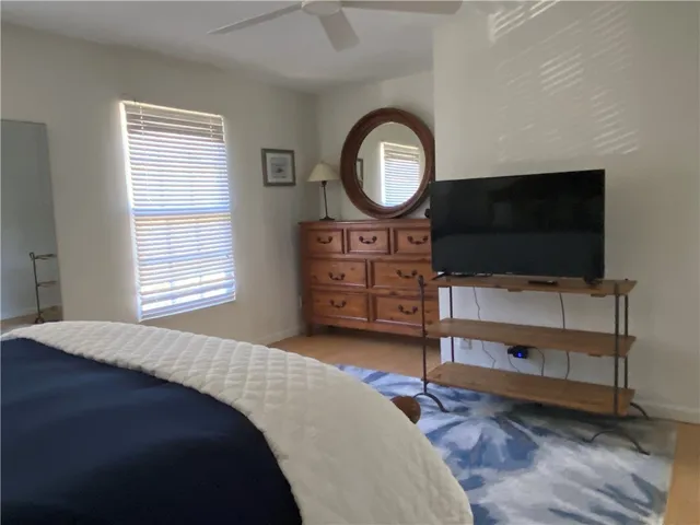 a bedroom with a bed and a flat tv screen on dresser