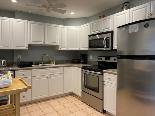 a kitchen with granite countertop white cabinets and stainless steel appliances
