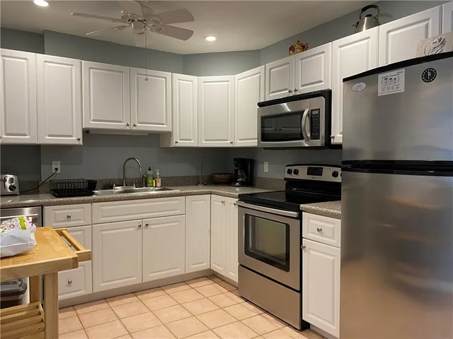 a kitchen with granite countertop white cabinets stainless steel appliances and sink