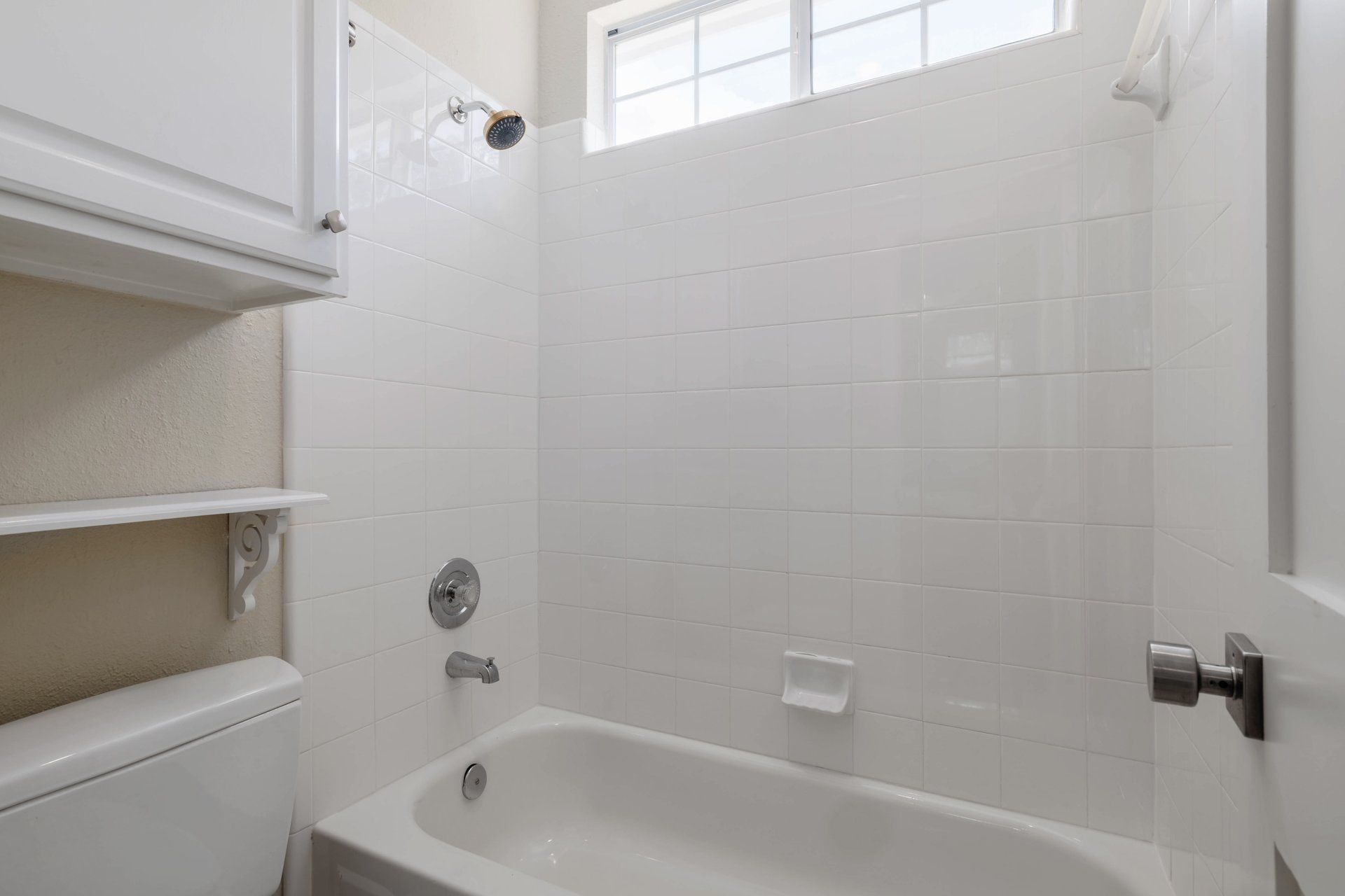 5512 Ballenton Lane Austin, TX 78739 - Photo 33 of 40 A well-maintained bathroom with a tub and shower, featuring a window for natural light.