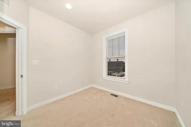 a front view of a house with a yard and potted plants
