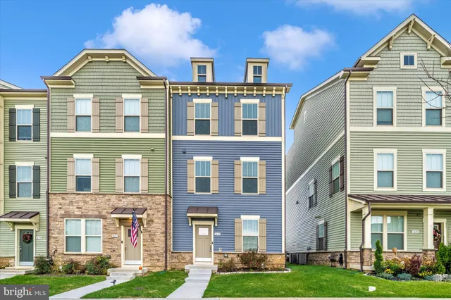 a kitchen with stainless steel appliances granite countertop a stove a refrigerator a sink a dining table and chairs with wooden floor