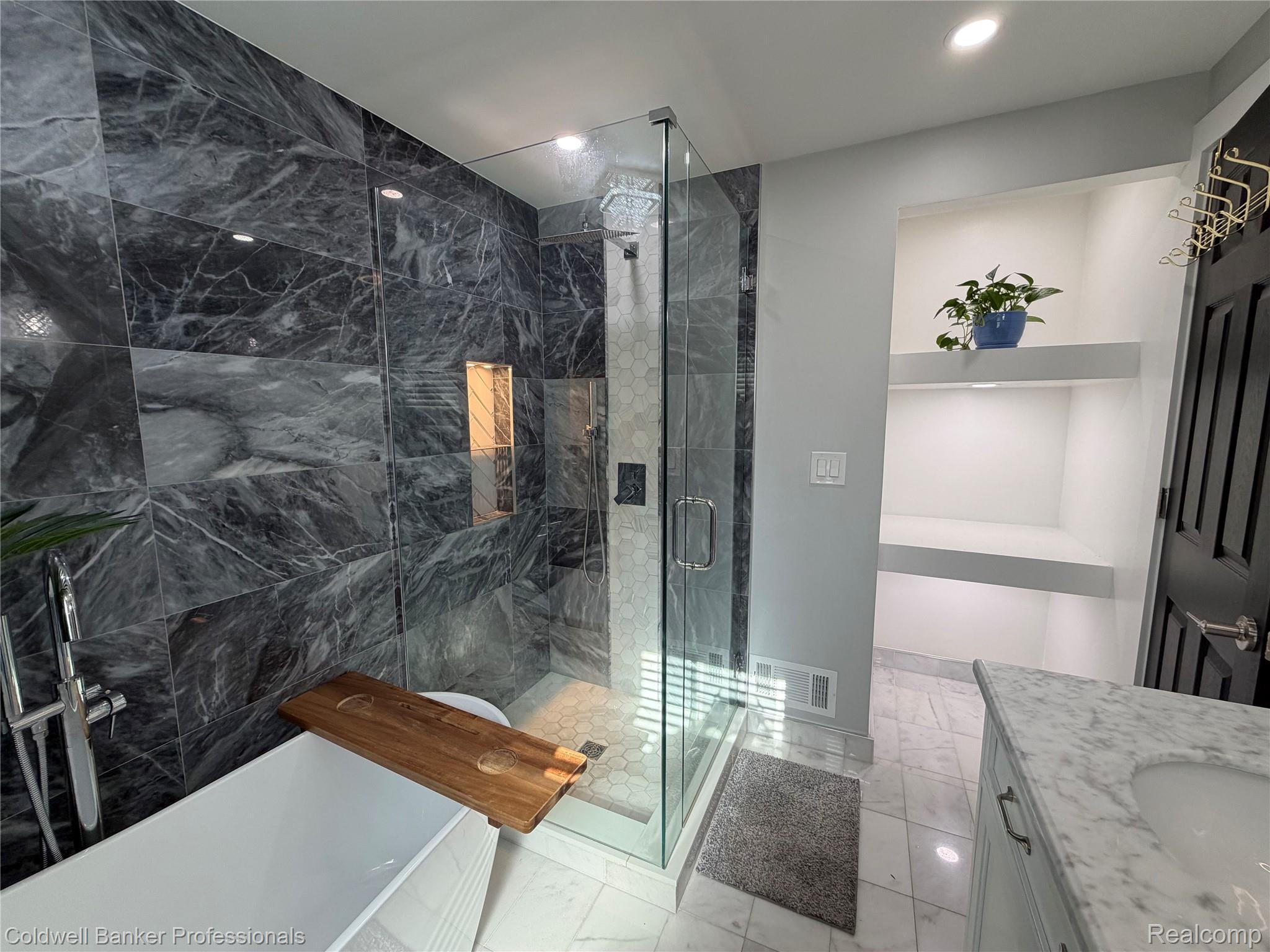 1168 Vernier Road Grosse Pointe, MI 48236 - Photo 19 of 37 Bathroom featuring a glass-enclosed shower with dark marble-style tile walls and a built-in niche