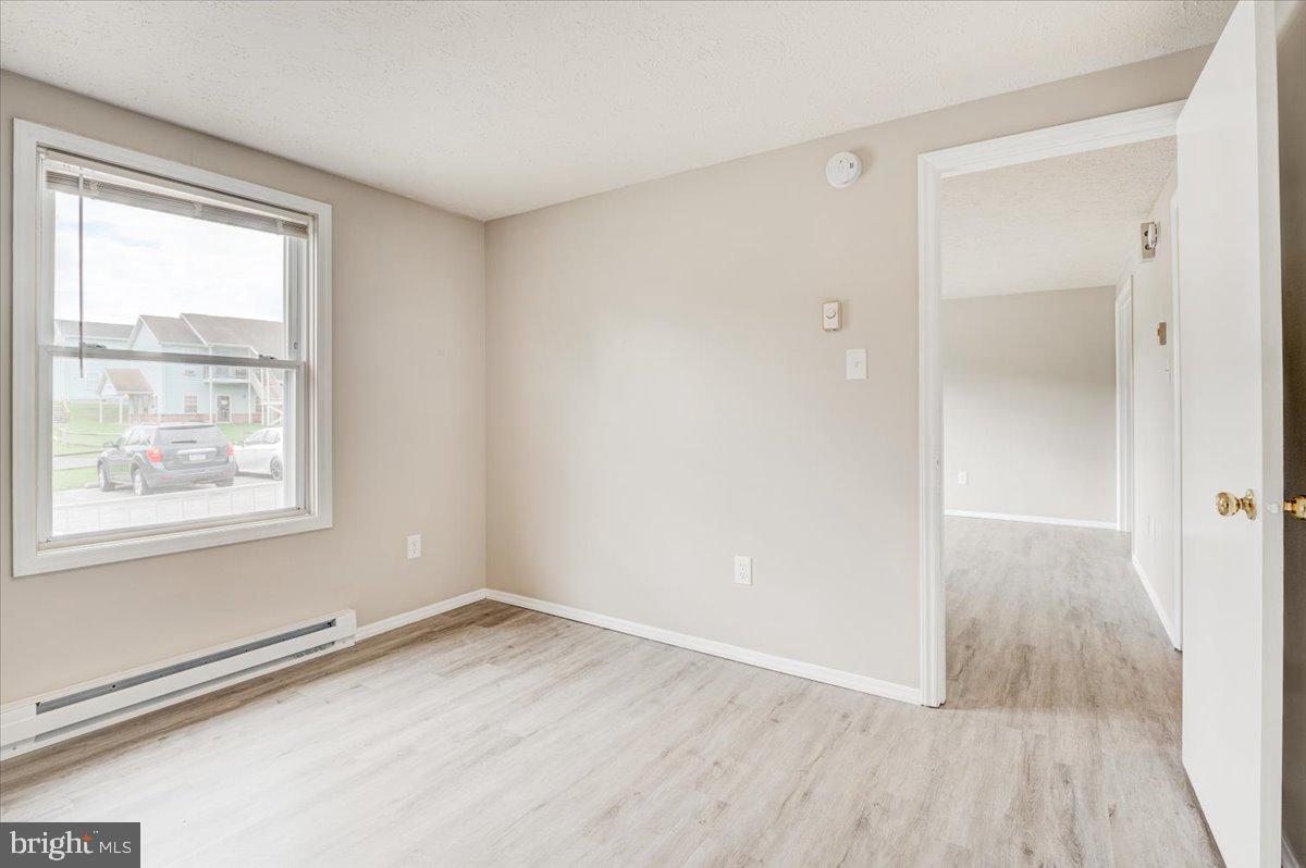 1867 Johnson Road Chambersburg, PA 17202 - Photo 11 of 16 an empty room with wooden floor and windows