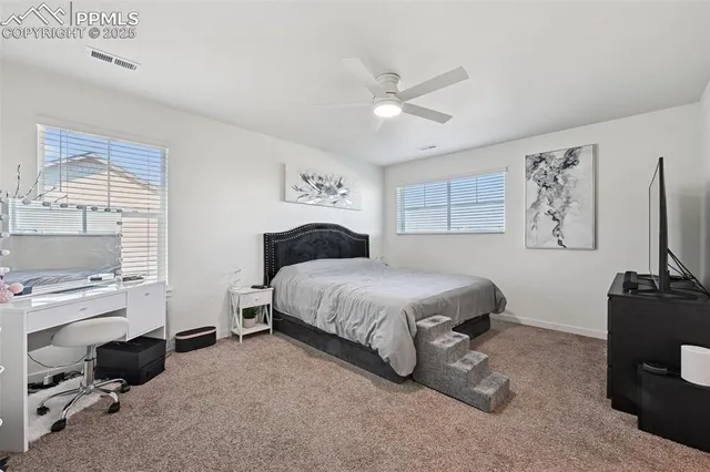 a spacious bedroom with a bed and a flat screen tv