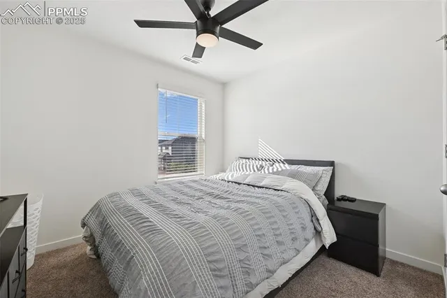 a bedroom with a bed and a ceiling fan