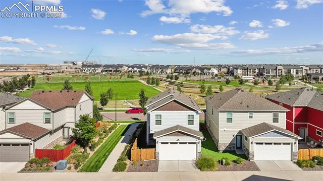 an aerial view of residential houses with outdoor space and ocean view