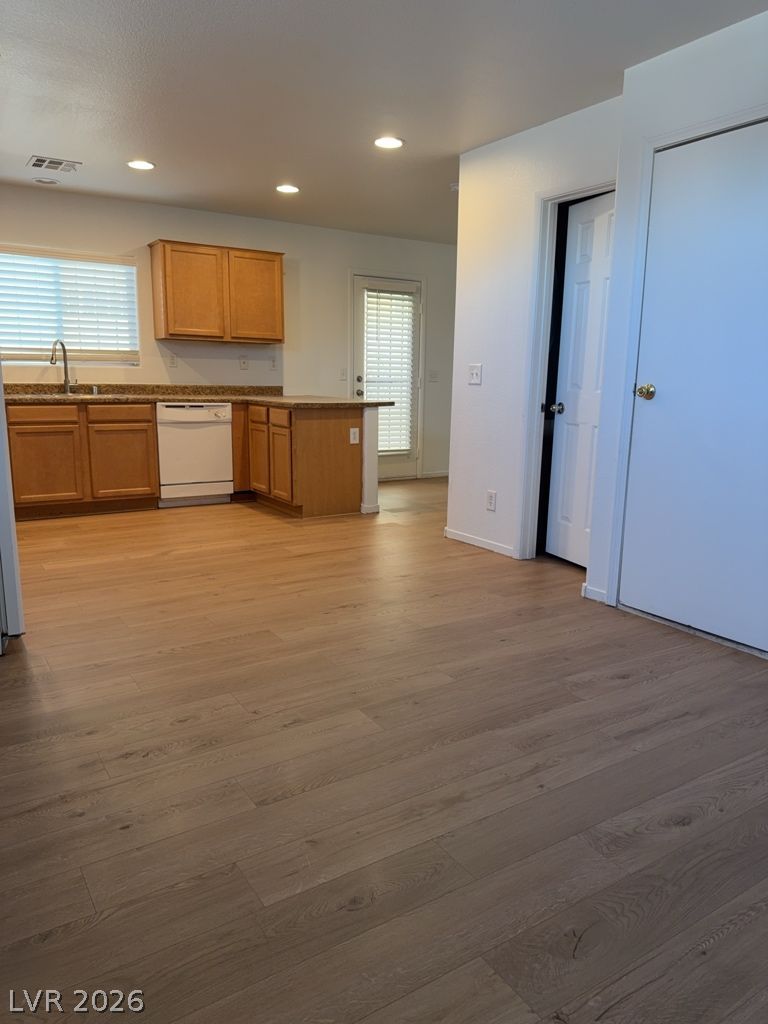 4790 Pinon Pointe Road Las Vegas, NV 89115 - Photo 4 of 16 A well-lit kitchen featuring a breakfast bar, ample cabinetry, and rich hardwood flooring.