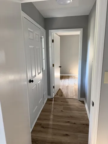 a view of a hallway with wooden floor and staircase