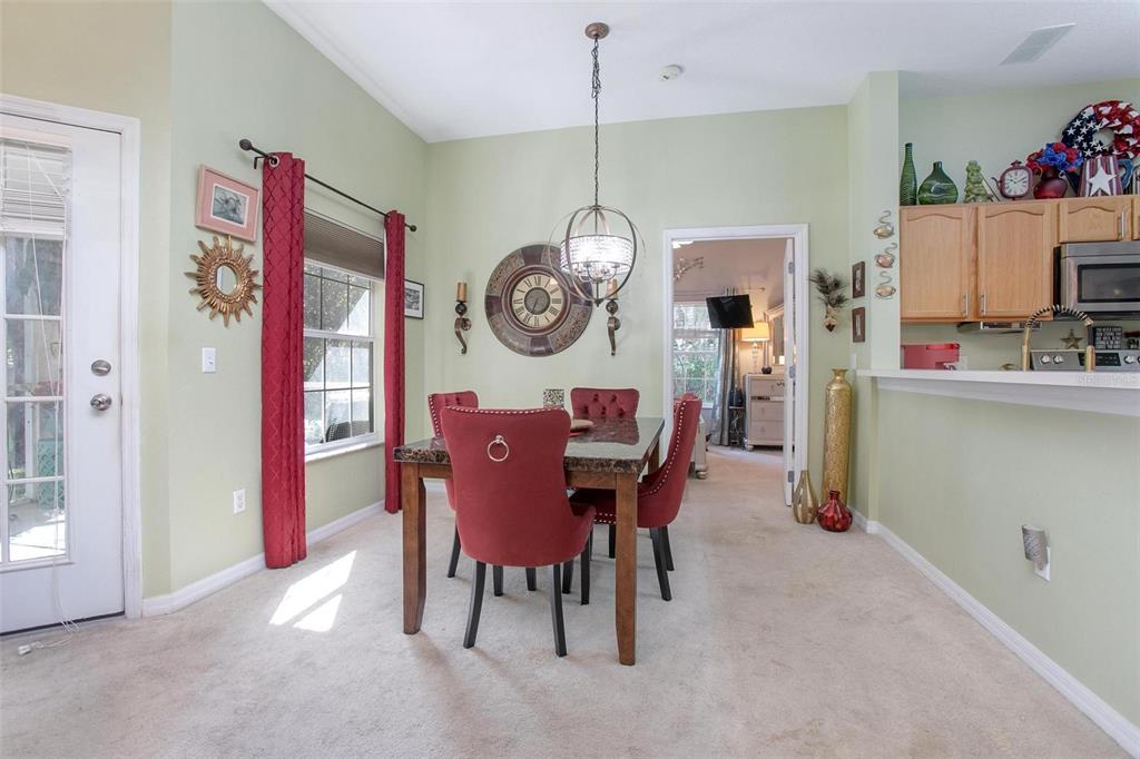 970 North Spring Garden Avenue, Unit 311 Deland, FL 32720 - Photo 6 of 23 a view of a dining room and livingroom with furniture wooden floor and a clock