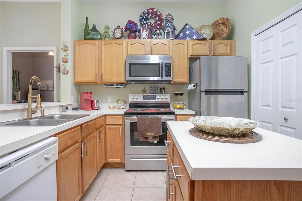 970 North Spring Garden Avenue, Unit 311 Deland, FL 32720 - Photo 9 of 23 a kitchen with stainless steel appliances a stove a sink and a refrigerator