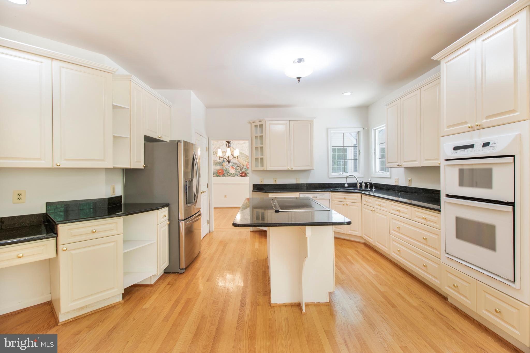 15302 Sweetridge Road Silver Spring, MD 20905 - Photo 22 of 106 a kitchen with granite countertop a refrigerator a stove top oven and white cabinets