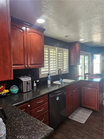 a kitchen with stainless steel appliances granite countertop wooden cabinets a sink and dishwasher