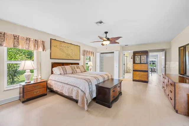 a spacious bedroom with a bed and wooden floor