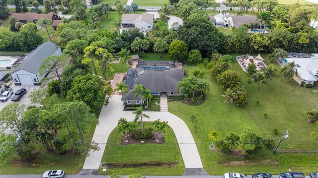 an aerial view of residential houses with outdoor space and trees
