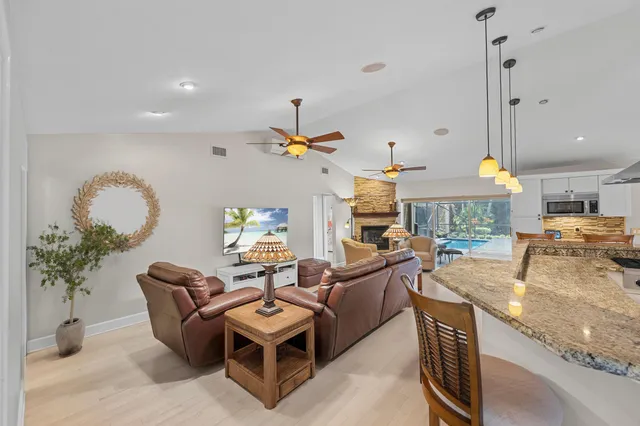 a living room with furniture a chandelier and a dining table