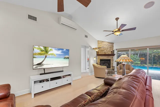 a living room with furniture a flat screen tv and a window