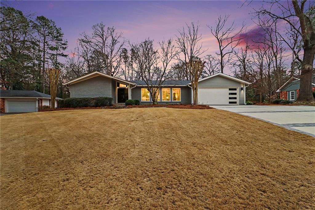 a front view of a house with a yard and covered with snow in front of house
