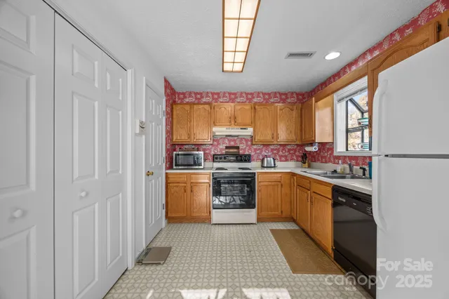 a kitchen with stainless steel appliances granite countertop a stove a sink and a refrigerator