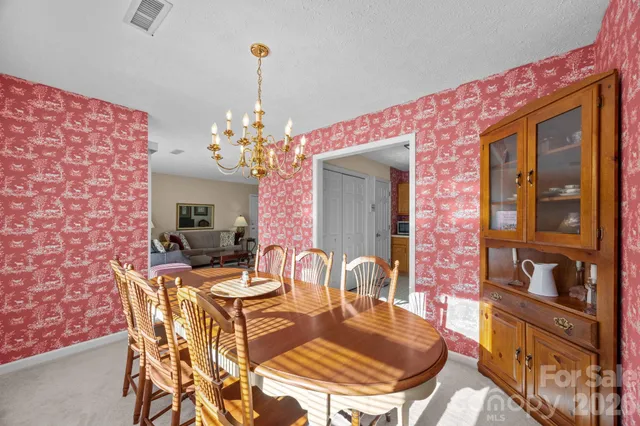 a view of a dining room with furniture and chandelier