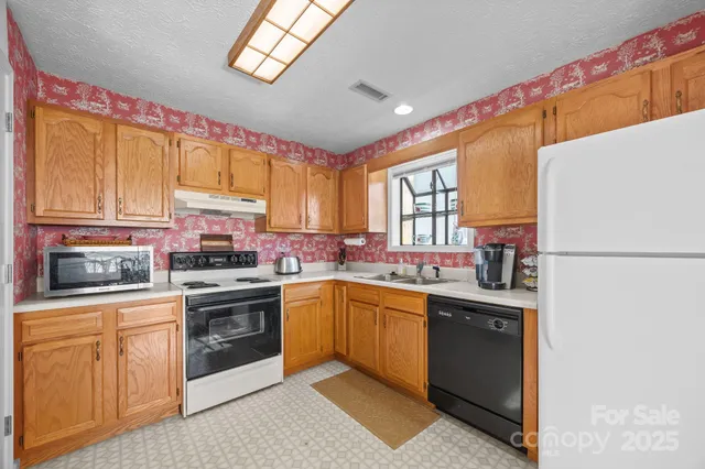 a kitchen with stainless steel appliances granite countertop a stove a sink dishwasher and a refrigerator