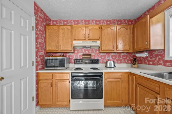 a kitchen with a stove top oven sink and cabinets
