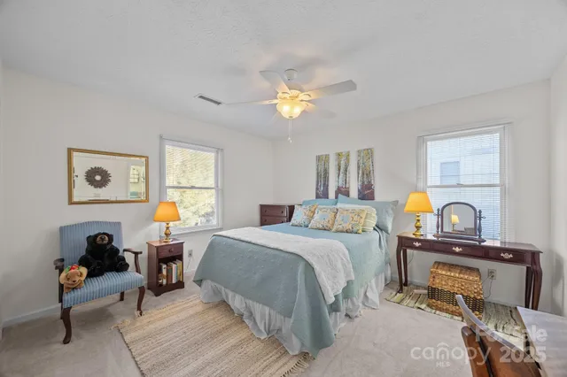 a bedroom with a bed a chandelier and dresser