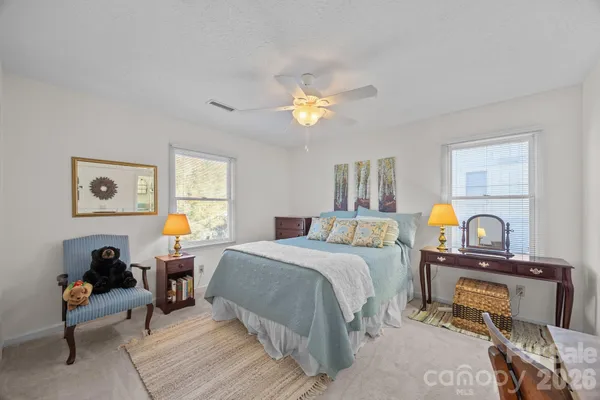 a bedroom with a bed a chandelier and dresser