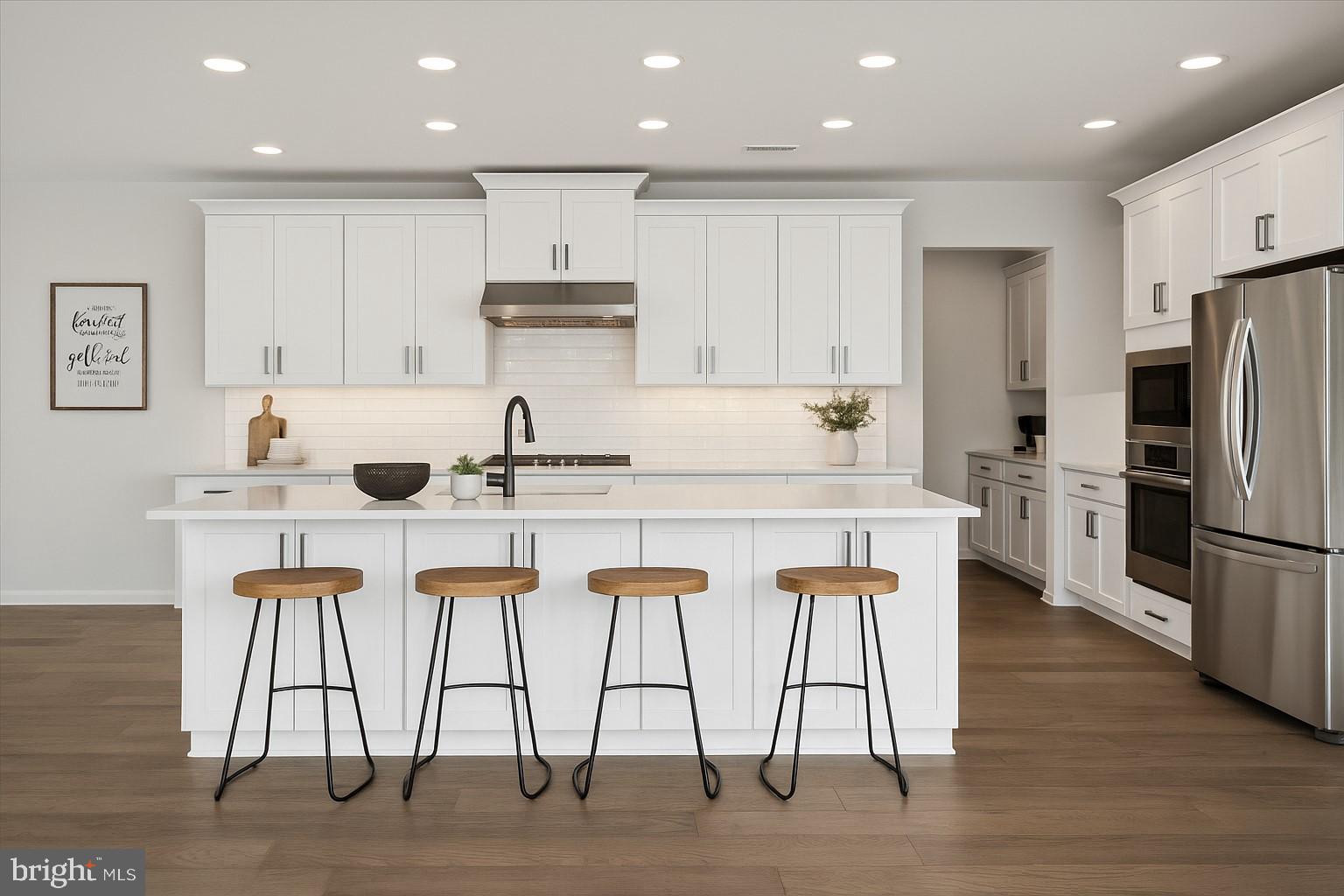 3174 Wier Drive East, Unit E Warrington, PA 18976 - Photo 12 of 37 a kitchen with stainless steel appliances kitchen island granite countertop a stove top oven a sink and white cabinets with wooden floor
