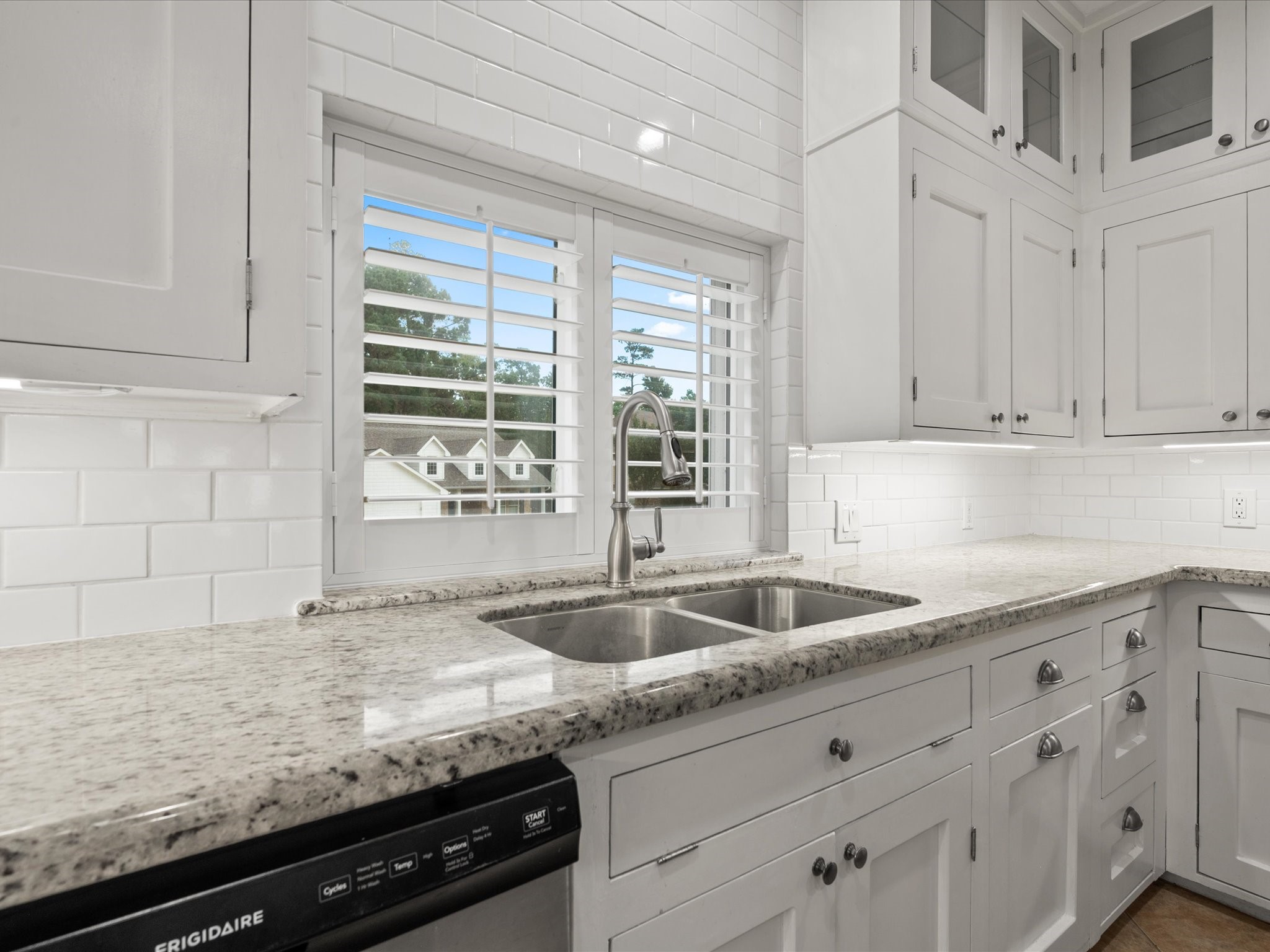 2906 Penninsula Point Montgomery, TX 77356 - Photo 13 of 48 Elegant granite countertops and
a subway tile backsplash
complete the look, creating a
bright, modern space that’s both
stylish and functional. Natural
light pours in through the window
above the sink, adding warmth
and charm to this inviting
culinary space.