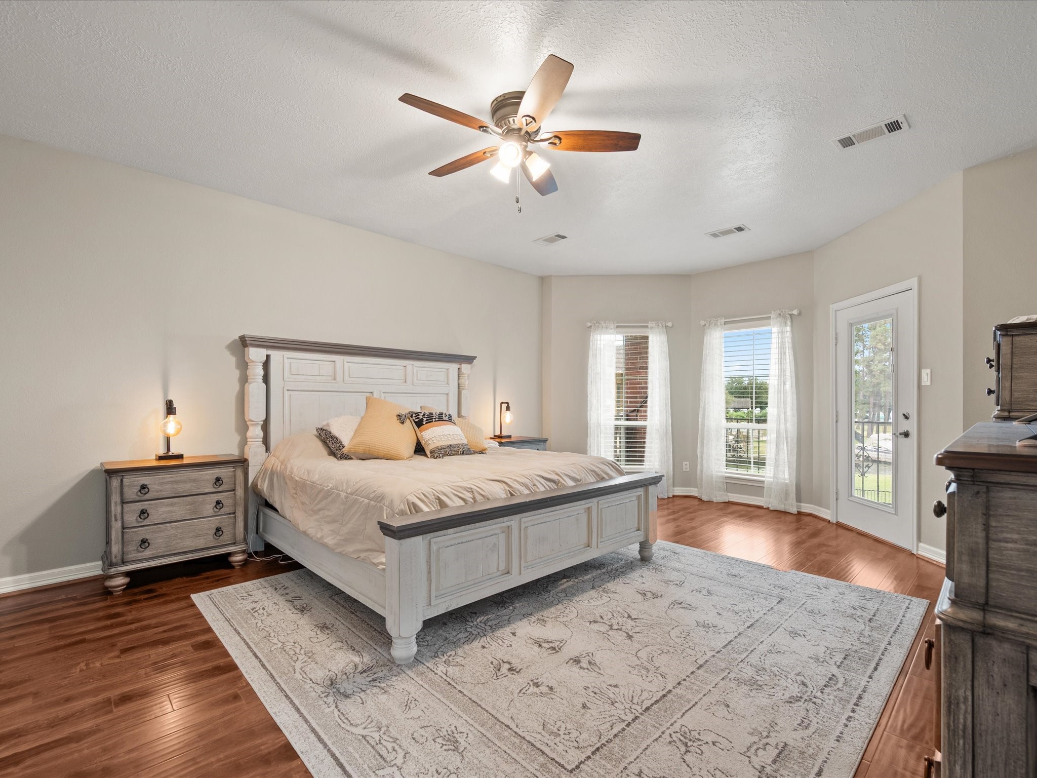 2906 Penninsula Point Montgomery, TX 77356 - Photo 17 of 48 The spacious primary bedroom
is a serene retreat, flooded with
natural light from large, elegant
windows. Step out onto the
covered balcony to enjoy fresh
air and peaceful lake views,
creating the perfect balance of
comfort, luxury, and relaxation.