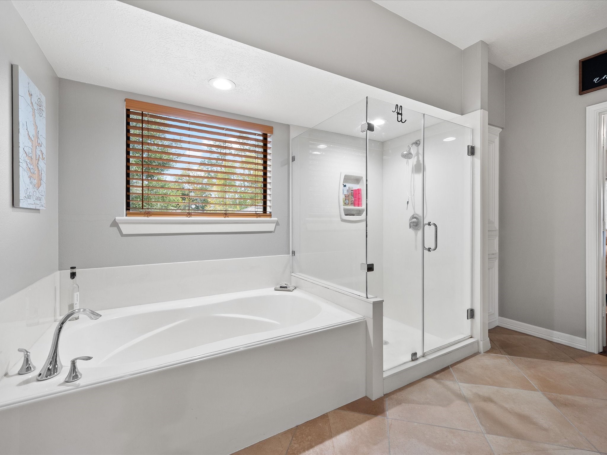 2906 Penninsula Point Montgomery, TX 77356 - Photo 20 of 48 The luxurious primary bathroom
features a separate vanity space
for added convenience, a
stunning glass-enclosed walk-in
shower, and a freestanding
soaking tub, creating a spa-like
retreat designed for relaxation
and indulgence.