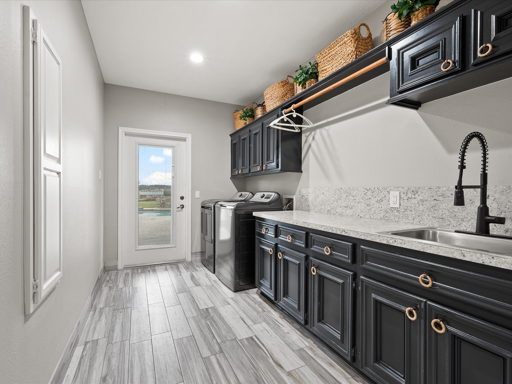 2906 Penninsula Point Montgomery, TX 77356 - Photo 29 of 48 Spacious utility room with
washer/dryer hookups, abundant
storage, counter space, and a
sink—perfect as a mudroom with
direct pool access.