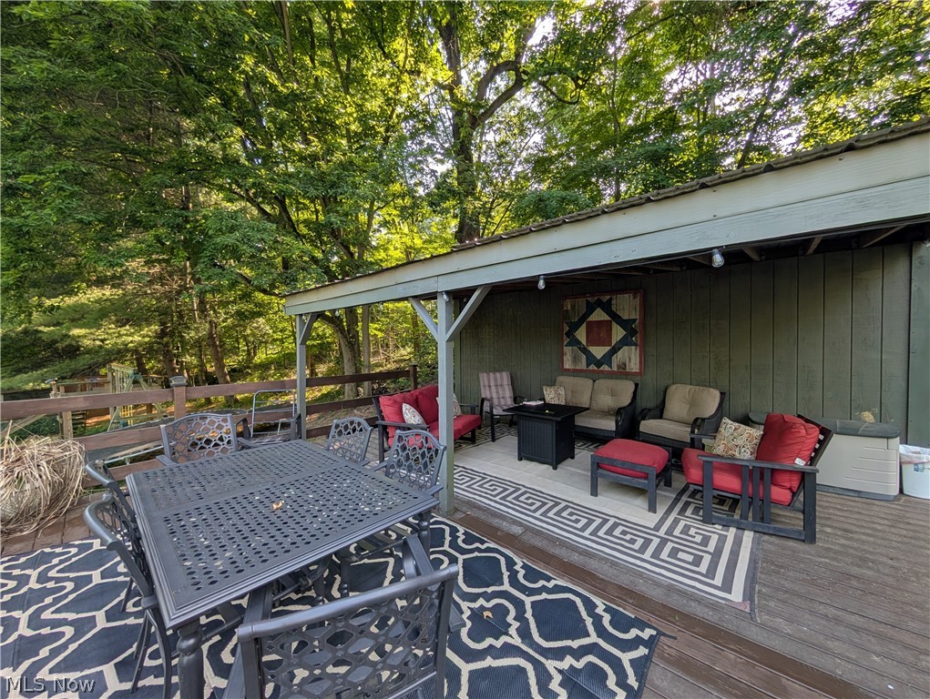 6700 McCaslin Road Nashport, OH 43830 - Photo 5 of 30 Expansive outdoor deck featuring a covered patio area with exposed wooden beams, recessed lighting, and a painted wood-panel wall
