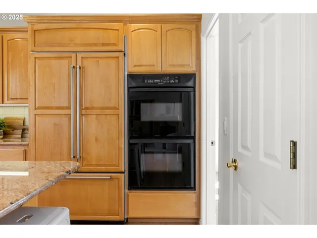 a kitchen with stainless steel appliances granite countertop a refrigerator and a stove