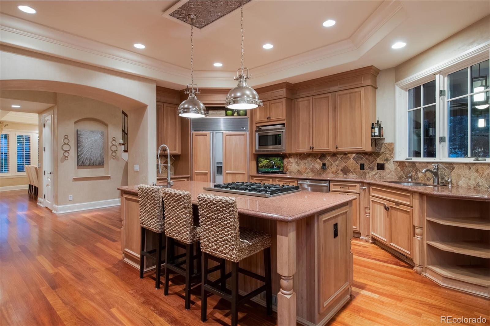 3 Sandy Lake Road Englewood, CO 80113 - Photo 14 of 35 a kitchen with stainless steel appliances granite countertop a stove top oven a sink dishwasher a dining table and chairs with wooden floor