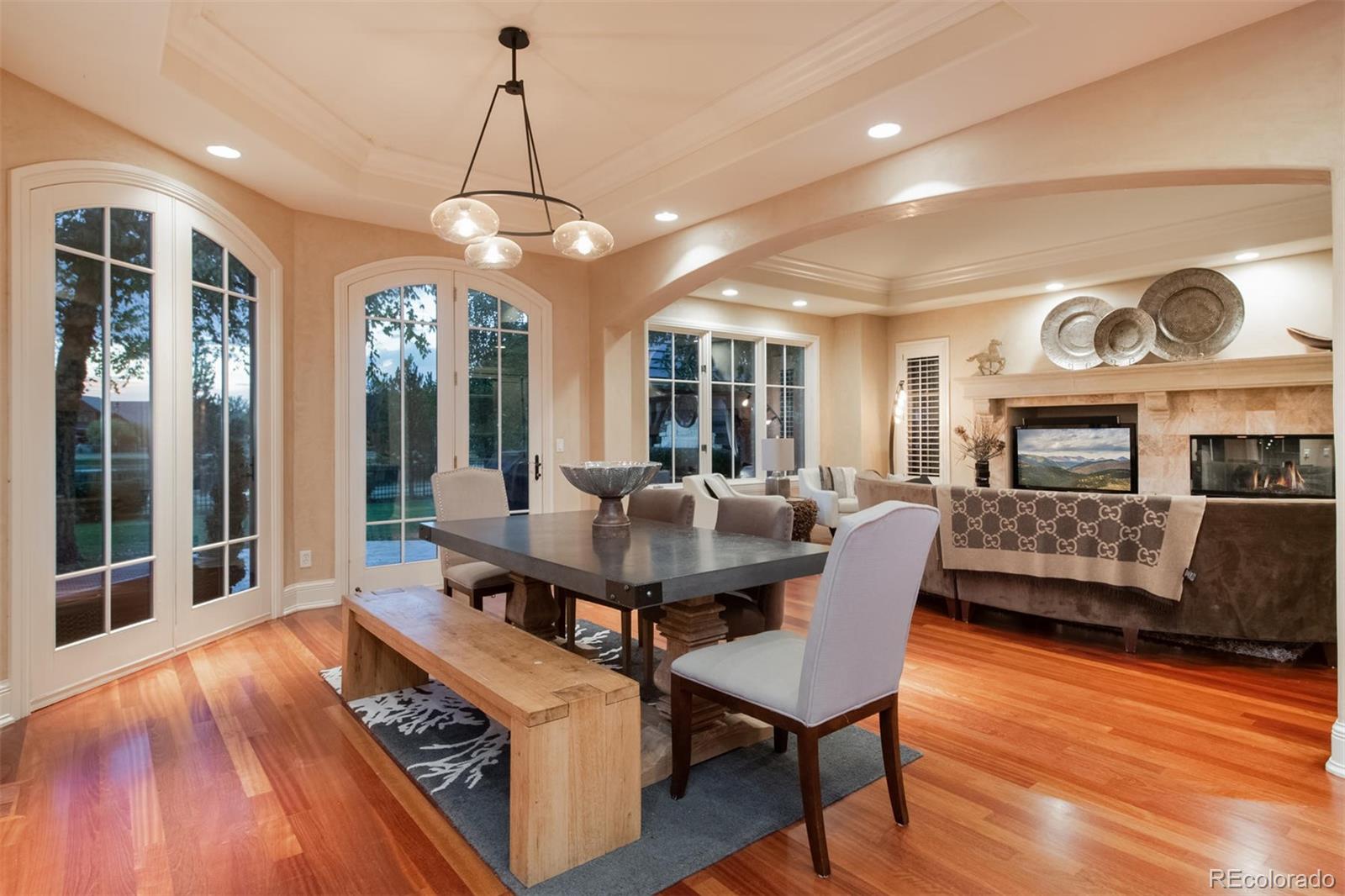 3 Sandy Lake Road Englewood, CO 80113 - Photo 16 of 35 a dining room with wooden floor a chandelier a glass table and chairs