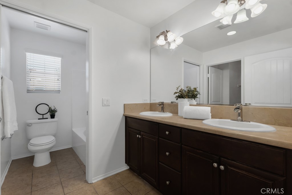 20317 Livorno Porter Ranch Porter Ranch, CA 91326 - Photo 18 of 33 a bathroom with a double vanity sink and a toilet