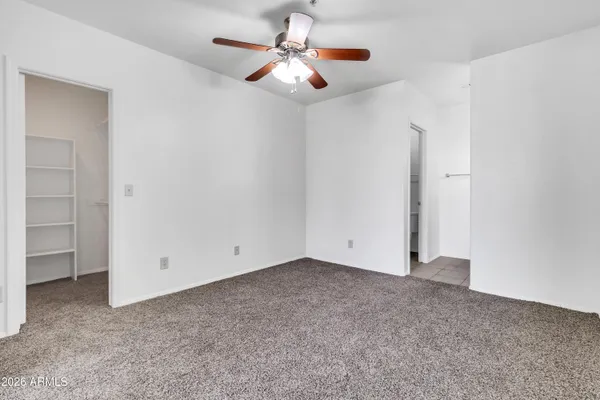 an empty room with a ceiling fan and a window