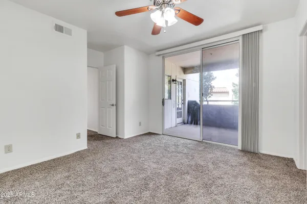 a view of an empty room and chandelier fan