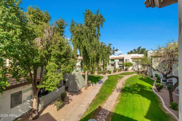 a view of yard with outdoor seating and trees in the background