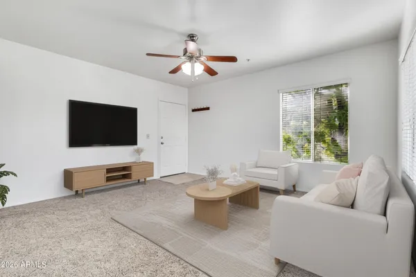 an empty room with windows and fan