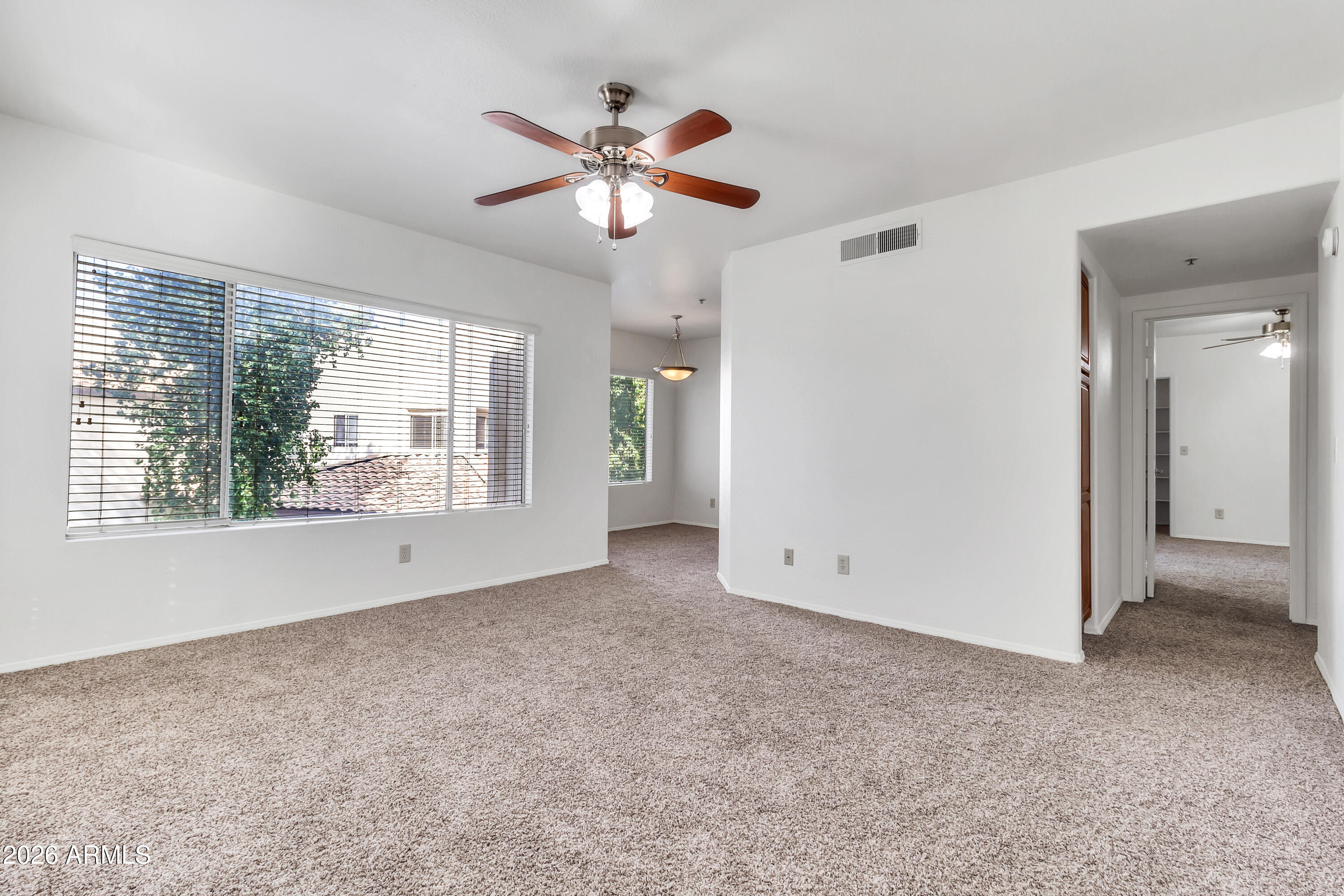 1825 West Ray Road, Unit 2072 Chandler, AZ 85224 - Photo 47 of 47 an empty room with chandelier fan and windows