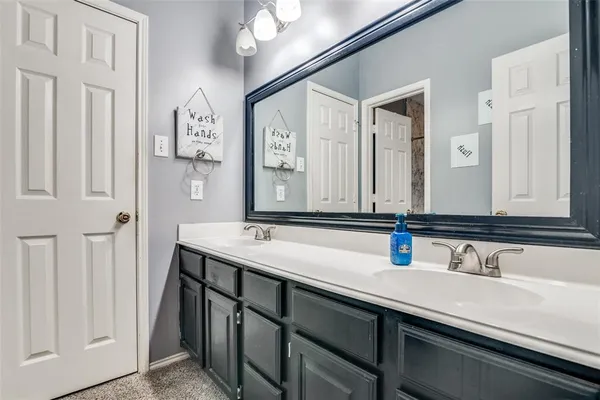 a bathroom with double vanity sinks and a mirror
