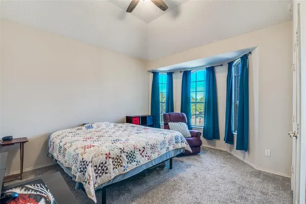 a bedroom with a bed lamp and a large window