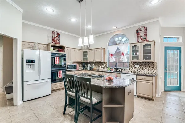 a kitchen with stainless steel appliances a dining table and chairs