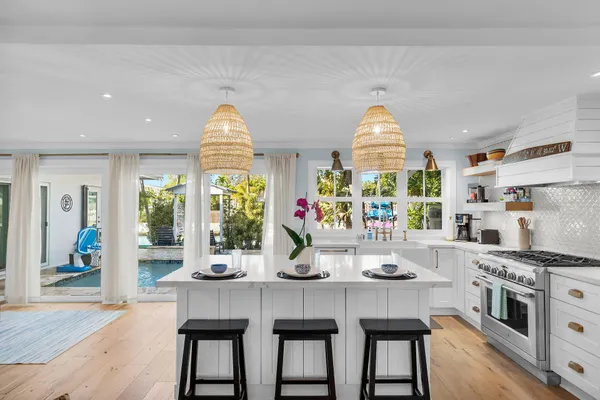 a kitchen with stainless steel appliances a dining table and chairs in it
